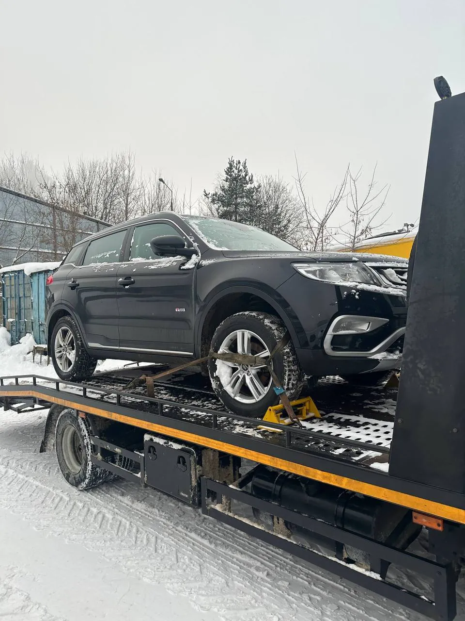Погрузка Geely на эвакуатор зимой для доставки в сервис в Минске