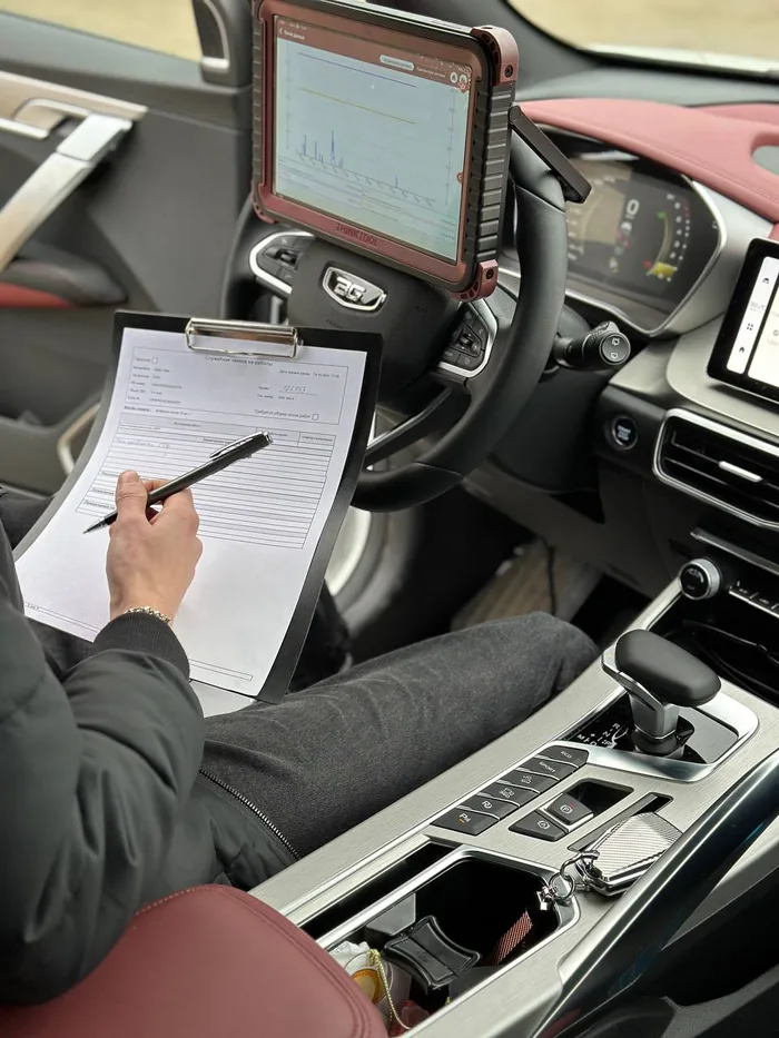 Мастер Geely-Service с планшетом в салоне автомобиля